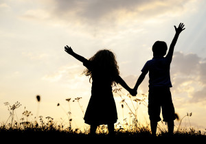 Silhouette, group of happy children playing on meadow, sunset, s